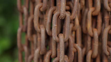 close up of rusty old metal chain hanging vertically, detailed rusted texture