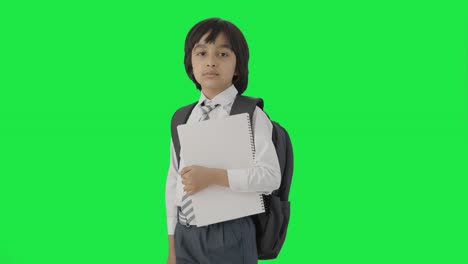 retrato de un niño de escuela indio de pie con libros pantalla verde