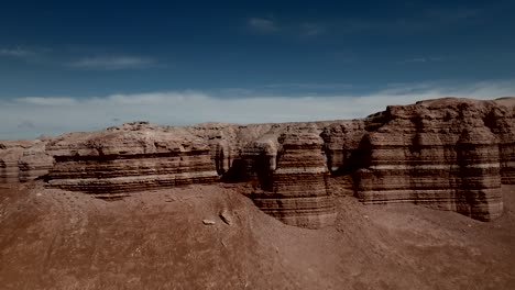 Red-sandstone-sedimentary-cliffs---flying-between-to-reveal-the-desert-landscape