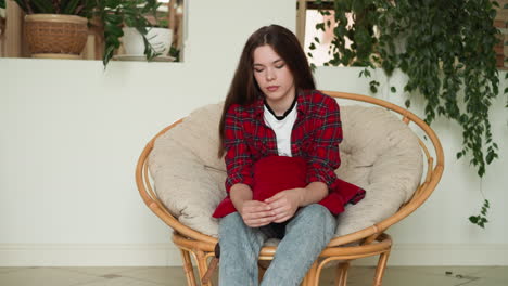 a young woman sits in a chair with her arms crossed