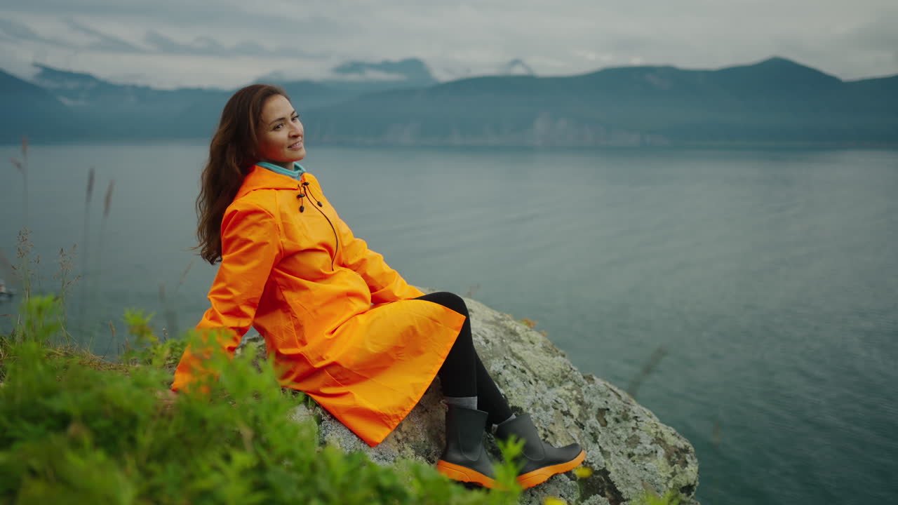 Woman in Orange Raincoat by the Lake