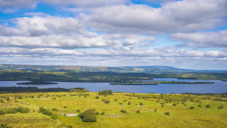 timelapse de la naturaleza rural tierras de cultivo con turbinas eólicas en las colinas y el lago en la distancia durante un día soleado y nublado visto desde carrowkeel en el condado de sligo en irlanda