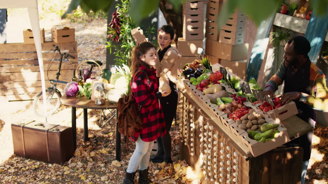 People buying and selling vegetables at a farmer's market