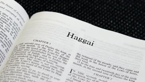 close up shot of bible page turning to the book of haggai