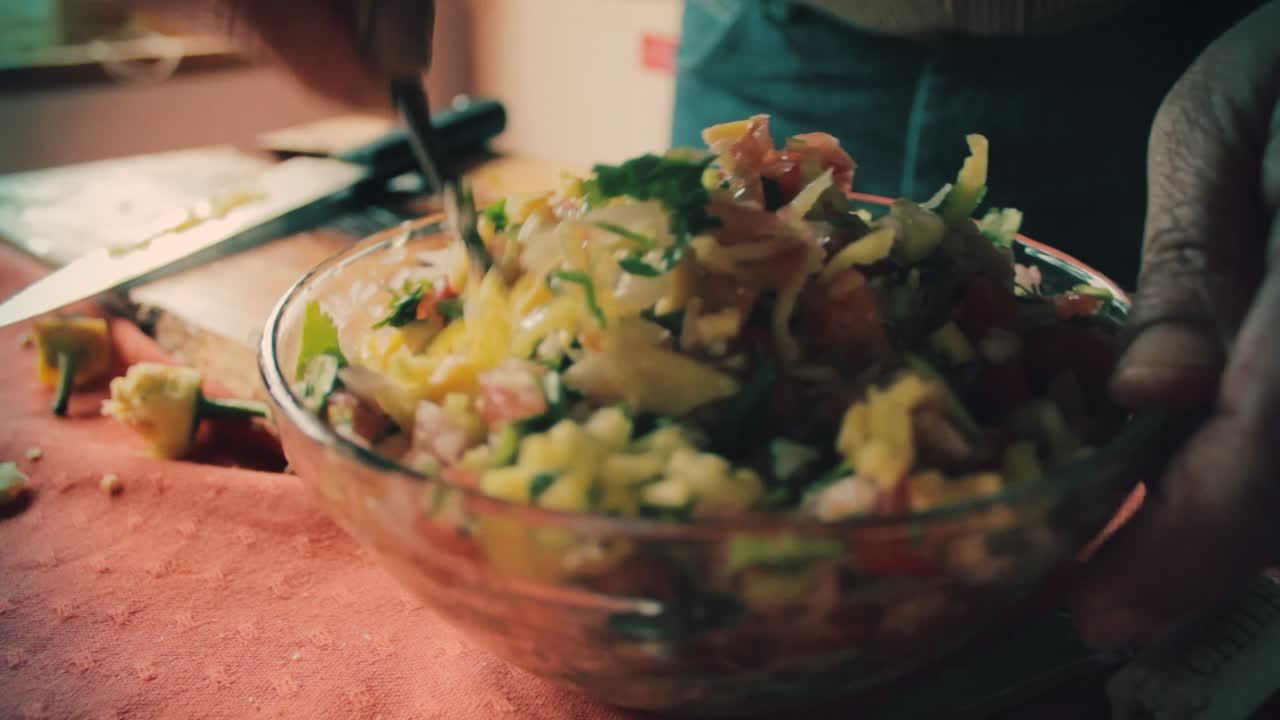 chef mezclando todas las verduras con una cuchara en un bol