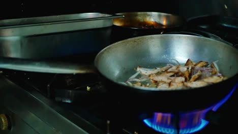chicken cooking in a pan in an open flame