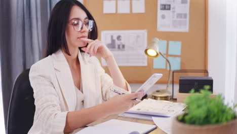 Selbstbewusste-Geschäftsfrau-Nutzt-Smartphone-Während-Der-Arbeit-Im-Büro