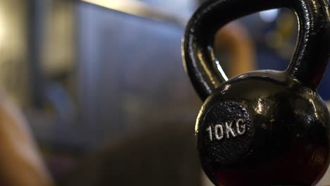 primer plano de la campana de la tetera en el gimnasio, banco de atletas presionando en un fondo borroso