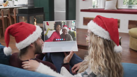 Glückliches,-Vielfältiges-Paar,-Mutter-Und-Tochter-Mit-Weihnachts-Laptop-Videoanruf,-Zeitlupe