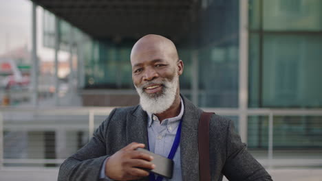 portrait of senior african american businessman ceo using smartphone looking confident at camera enjoying corporate lifestyle success