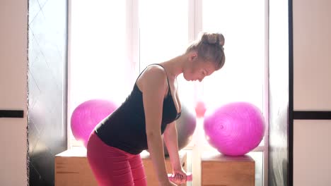 young pregnant woman doing exercises on a fitness ball at home young pregnant woman doing exercises on a fitness ball in her cozy living room promoting relaxation and wellbeing during pregnancy