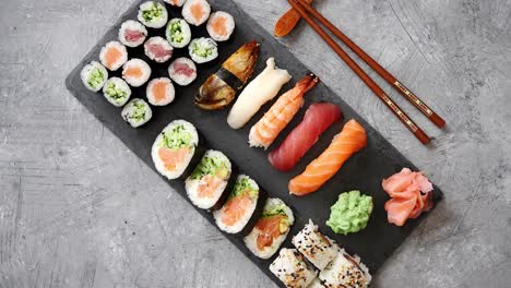 composition of different kinds of sushi rolls placed on black stone board