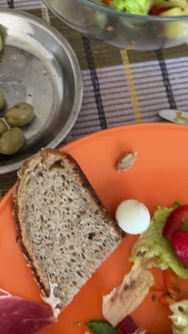 picnic lunch with salad, bread, ham and olives