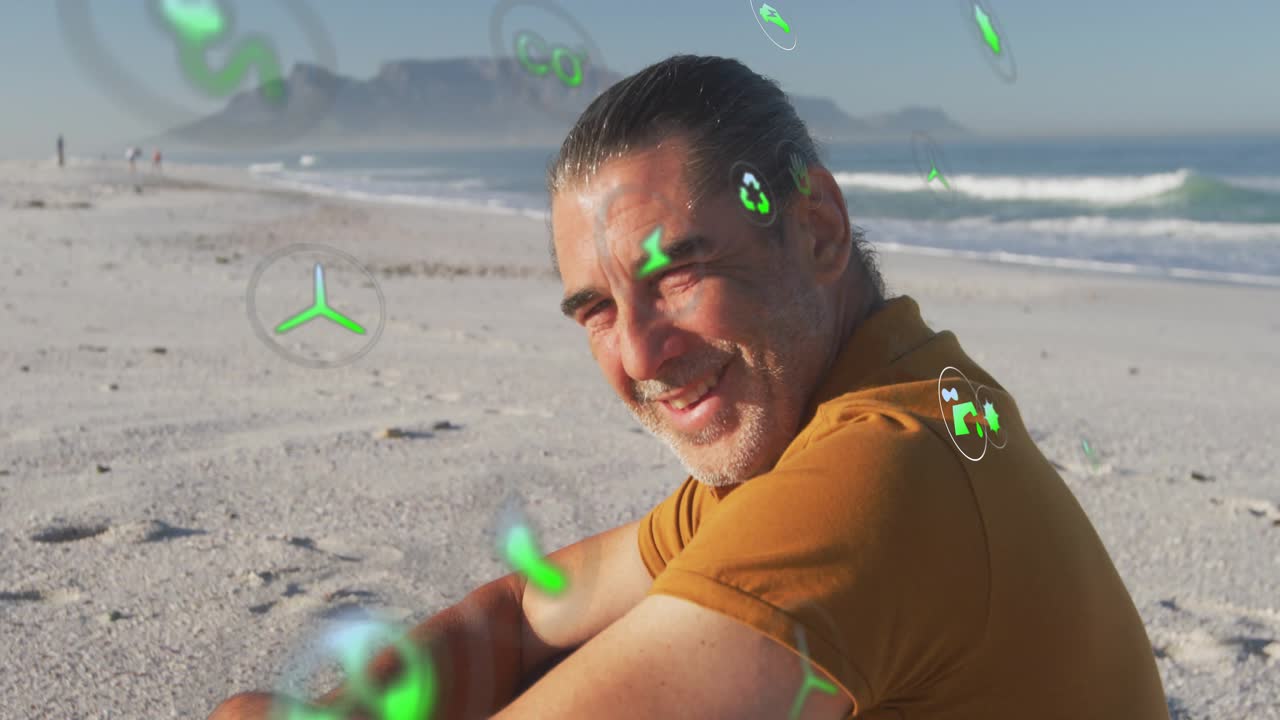 Senior man sitting on beach turning head smiling at camera eco icons swirling for sustainability