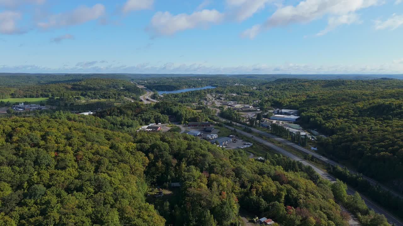Drone moving forward over the forest near Huntsville, Muskoka, with Highway 11 visible cutting through the trees