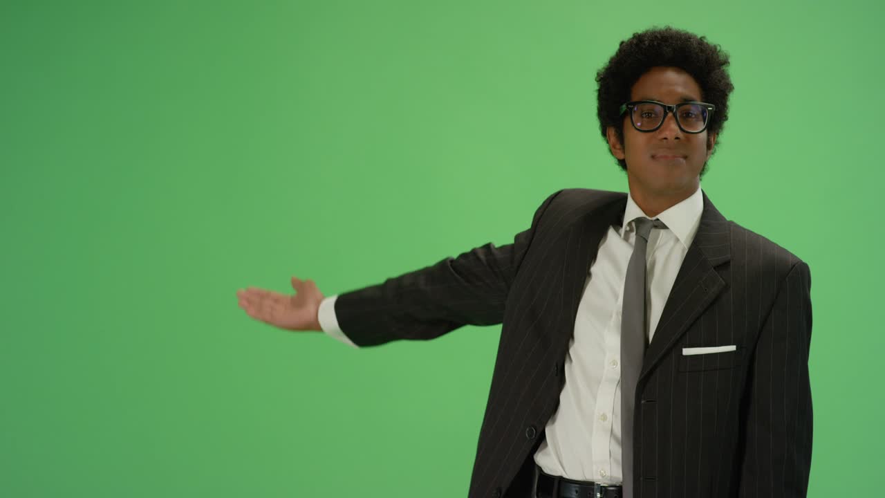 Businessman gestures with one arm on green screen