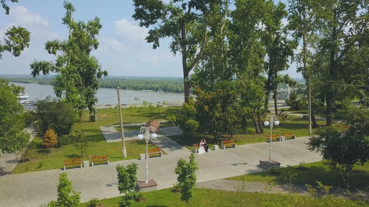 pareja recién casada en el parque verde cerca de la iglesia vista a vista de pájaro