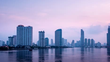 timelapse - bangkok city at sunrise with lighted at the downtown area with the chao phraya river.