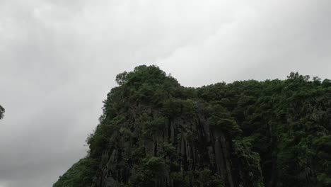 Lange-Neigbare-Drohne-Schoss-Von-Der-Spitze-Der-Berge-Im-Dschungel-In-Das-Tal-Eines-Kleinen-Dorfes-Und-Eines-Sees-In-Nin-Bihn,-Vietnam