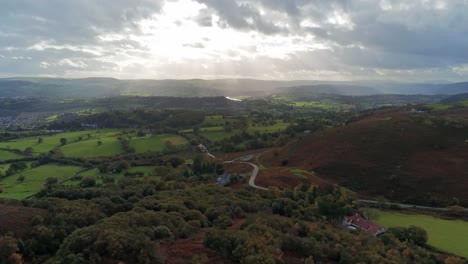 Sunrays-moving-across-rural-English-farmland-countryside-early-dawn-aerial-view-dolly-left