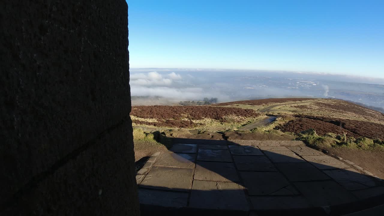 punto de vista de la entrada del monumento de piedra nubes arremolinadas que pasan por tierras de cultivo páramos campo timelapse en un día soleado