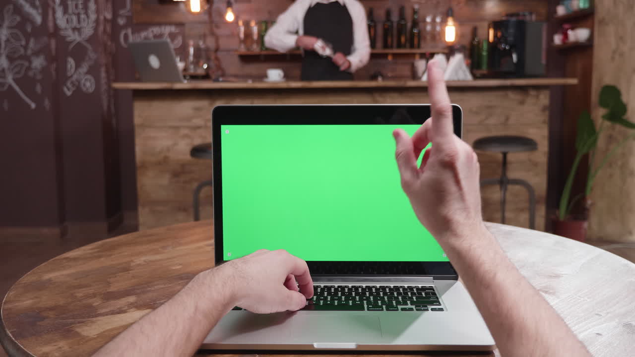 Laptop with green screen in a bar