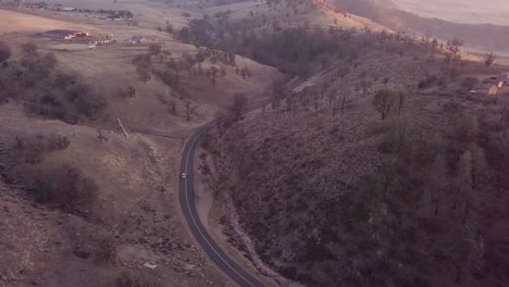 Luftaufnahme-Eines-Autos,-Das-Zur-Goldenen-Stunde-Durch-Die-Bergstraße-Fährt