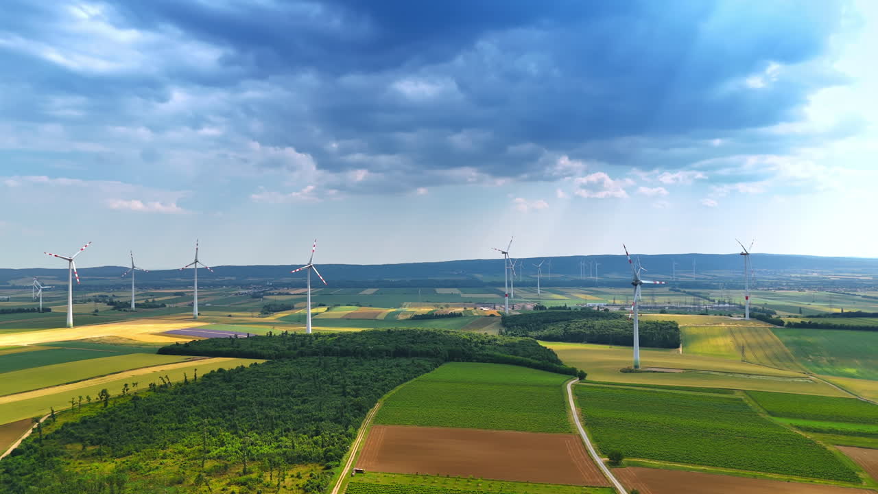 Grey cloudscape covering the sky over the countryside. Wind farms produce renewable energy