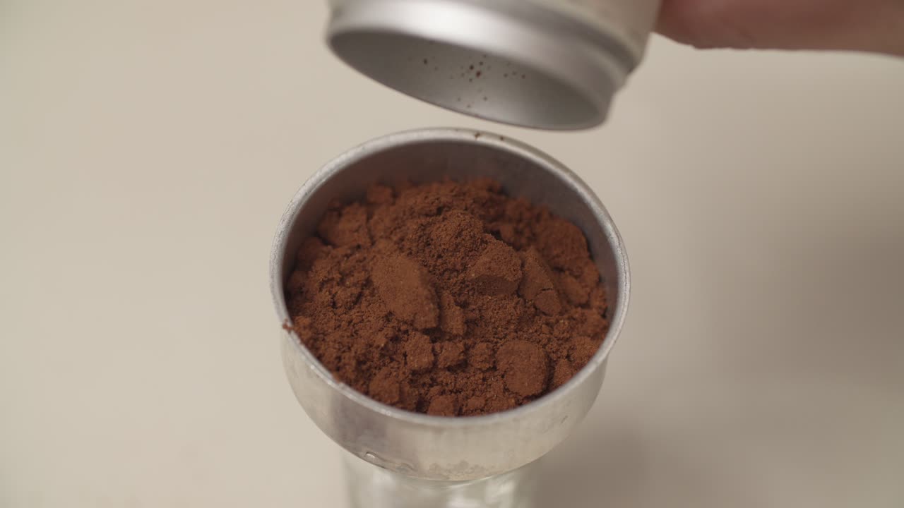 Pouring Coffee Grounds Into Container For Brewing. closeup shot