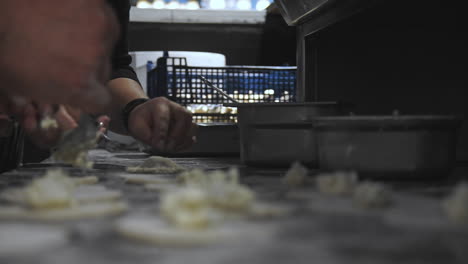 imágenes de primer plano de cocineros preparando panzerotti en un restaurante italiano