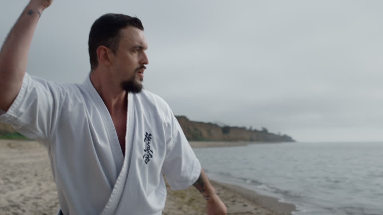 un luchador de karate haciendo ejercicios al aire libre en primer plano. un hombre haciendo ejercicios marciales.