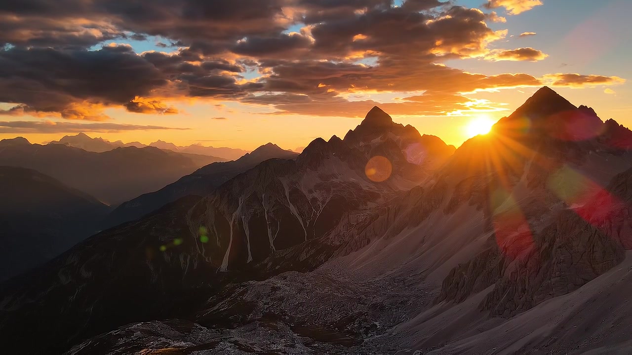 Pôr do sol deslumbrante sobre picos de montanhas escarpadas e céu dramático