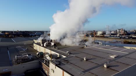 pull away from smoke bellowing from warehouse with horizon setting