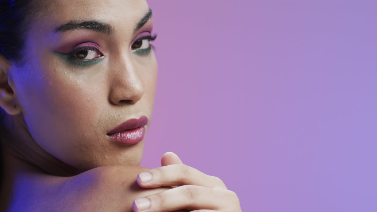 mujer biracial con cabello negro y maquillaje tocando su hombro, copia espacio, cámara lenta