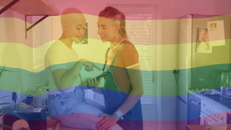 animation of rainbow flag over diverse female couple using smartphone