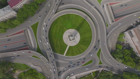 Ascending-birds-eye-view-shot-of-a-busy-roundabout-junction-filtering-onto-the-highway