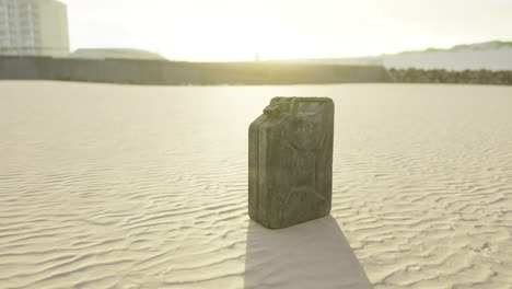 black container on sandy beach during sunrise with soft light reflections