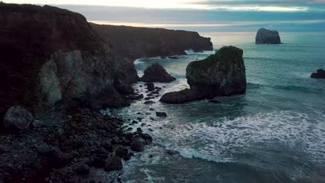 Truck-left-as-rolling-Pacific-Ocean-waves-crash-into-rocky-Sand-Dollar-Beach-at-dusk-in-Big-Sur-California