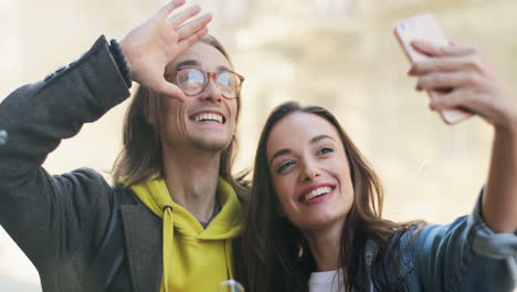 close-up view of young caucasian couple of friends taking selfies while transparent balls of soap falling