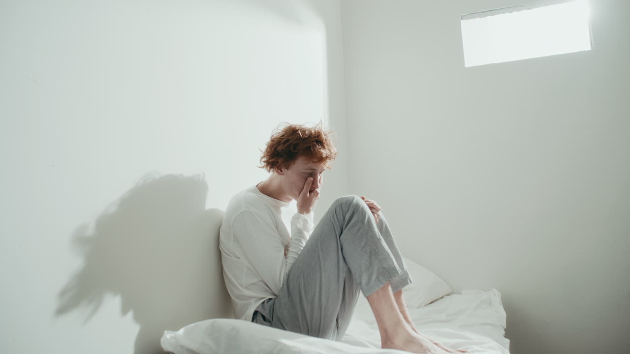 Anxious Patient Sitting on Bed in Psychiatric Ward