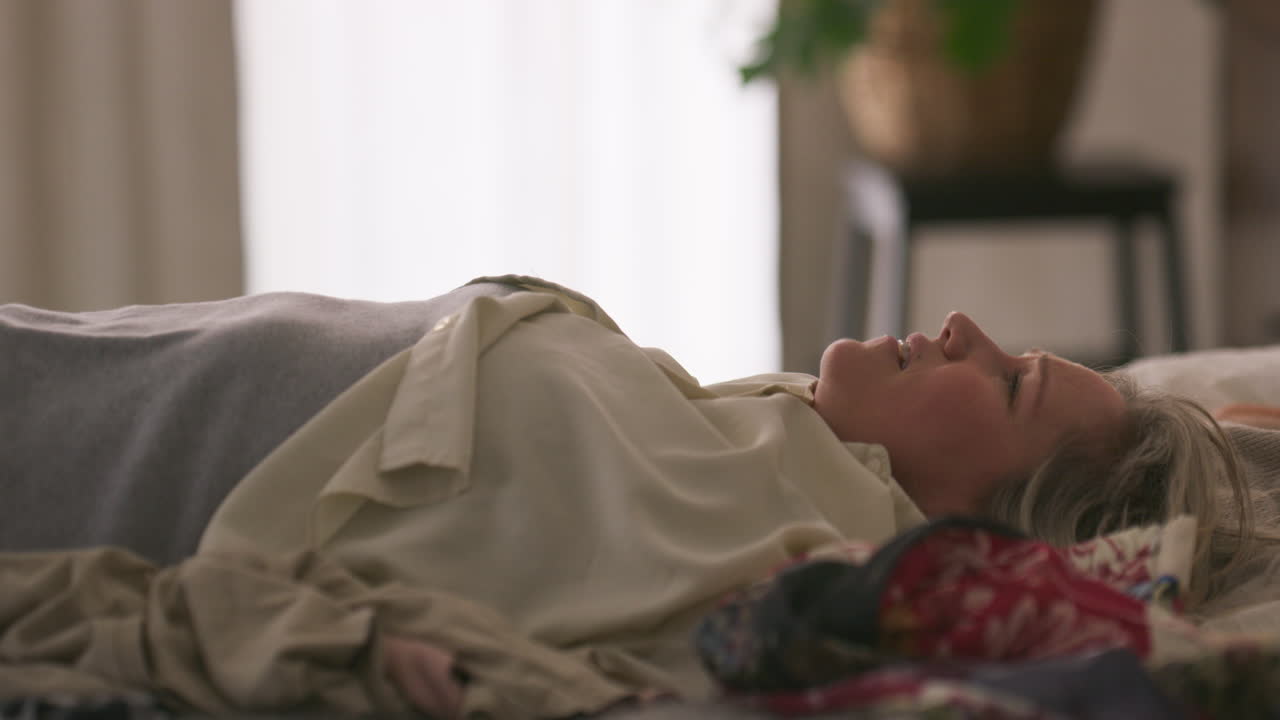 Woman lying down relaxing on a bed