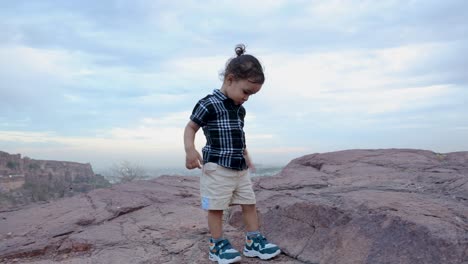 isolate infant walking at mountain rock at evening