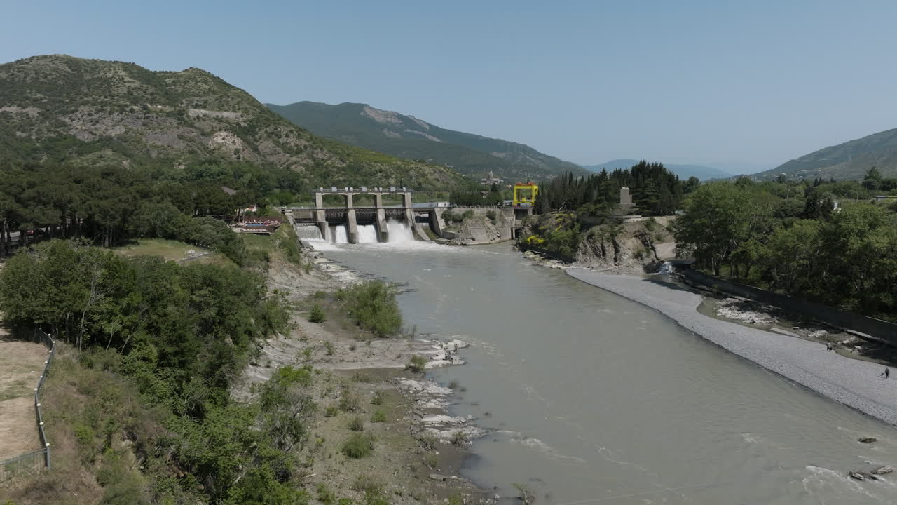 estación hidroeléctrica en el río kura con el fondo de la cordillera de las montañas del cáucaso cerca de la ciudad de mtskheta en georgia