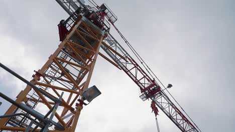 looking up at a construction crane against a moody overcast sky