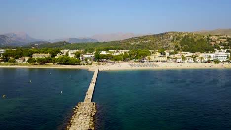 Playa-Del-Port-De-Pollença-En-Mallorca-En-Un-Día-Soleado,-Aguas-Cristalinas,-Vista-Aérea,-España,-En-El-Mar-Mediterráneo