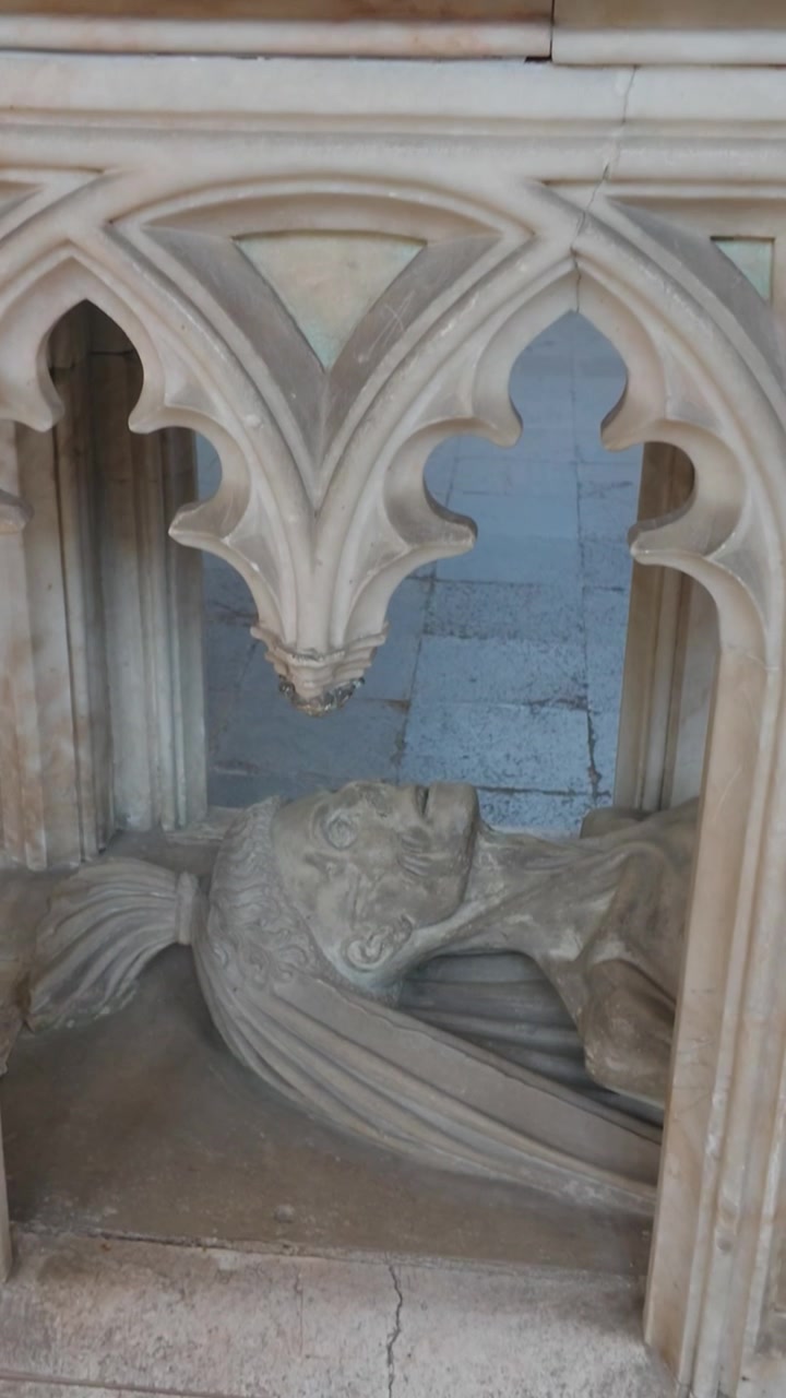Tomba a cadavere del XV secolo di John FitzAlan, 7° Conte di Arundel: un cadavere scolpito avvolto in un sudario giacente sotto trafori gotici nella Cappella Fitzalan al Castello di Arundel, West Sussex, Inghilterra. Panoramica verticale verso il basso