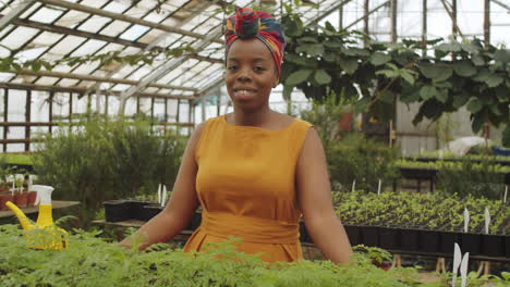 portrait of smiling african american woman in greenhouse