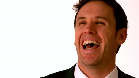 un hombre de negocios feliz riendo sobre un fondo blanco.
