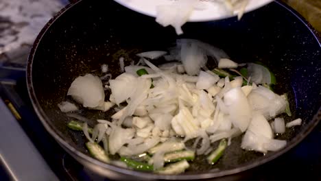 fresh sliced white onions being dropping into sizzling