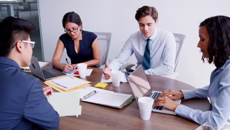 four young professionals brainstorming at a business meeting